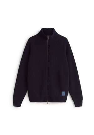 Gebreide donkerblauwe sweater met rits en hoge kraag, diagonale geribbelde textuur, en een klein blauw logoplaatje aan de onderkant vooraan.
