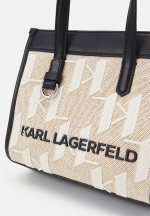 Beżowa i biała torebka w wzory z czarnymi skórzanymi uchwytami i czarnym logo "Karl Lagerfeld" z przodu.
