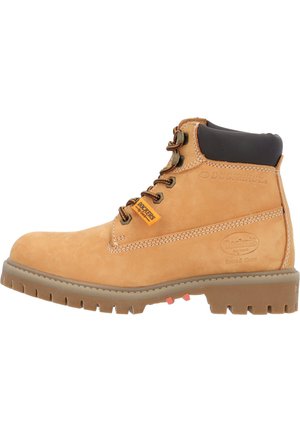 Tan suede ankle boots with brown accents, metal eyelets, and a rubber outsole featuring a rugged tread. Logo visible on the side.