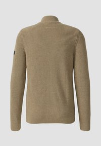 Beige gestrickter Pullover mit hohem Kragen, geripptem Muster, langen Ärmeln und einem Logodetail am linken Ärmel.