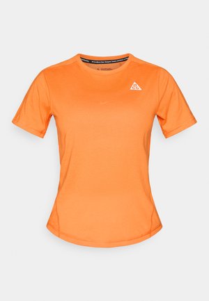 Short-sleeve orange athletic t-shirt made of soft fabric, featuring a triangle logo and a smooth texture with flat seams for comfort.