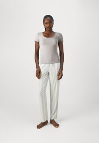 Maglietta grigia a maniche corte abbinata a pantaloni da pigiama a righe chiare con accenti blu chiaro. Vestibilità comoda con un design semplice.