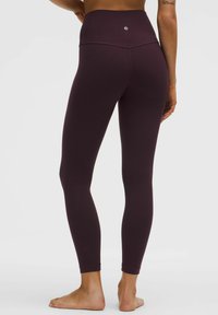 Bordové legíny s vysokým pasem vyrobené z elastického materiálu, s hladkým povrchem a výrazným logem na zadní straně. Úzký střih.