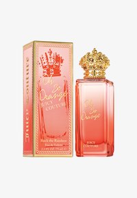 Orange glasparfymflaska med ett lock i form av en gyllene krona, placerad bredvid en orange och gyllene låda med texten "Oh So Orange Juicy Couture."