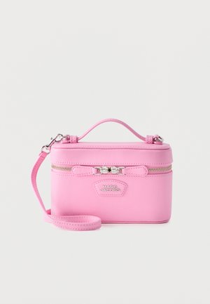 Petit sac à main rectangulaire rose Marc Jacobs avec poignée supérieure, bracelet de poignet détachable et fermeture éclair argentée.