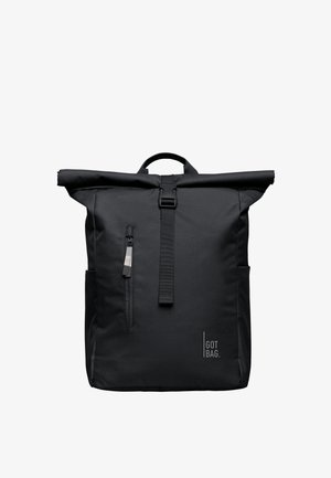 Sac à dos noir à rabat enroulable avec poche zippée à l'avant, sangle réglable avec boucle, poignée sur le dessus, et logo "GOT BAG." en bas à droite.