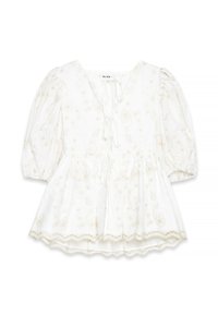 Blouse blanche avec broderies florales dorées, manches bouffantes, décolleté en V avec fermeture à nouer, taille froncée et ourlet festonné. Tissu texturé.