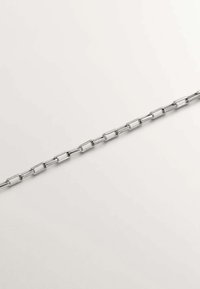 Cadena de eslabones rectangulares plateados dispuesta en diagonal sobre un fondo blanco liso.