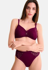 Bourgondische bh en hooggezette slipset, met geometrische patronen, gestructureerd materiaal, verstelbare bandjes en contrasterende mesh accenten.