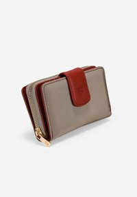 Billetera compacta en color beige y marrón con un cierre de cuero rojo y cremallera dorada, con una letra B grabada en el cierre.