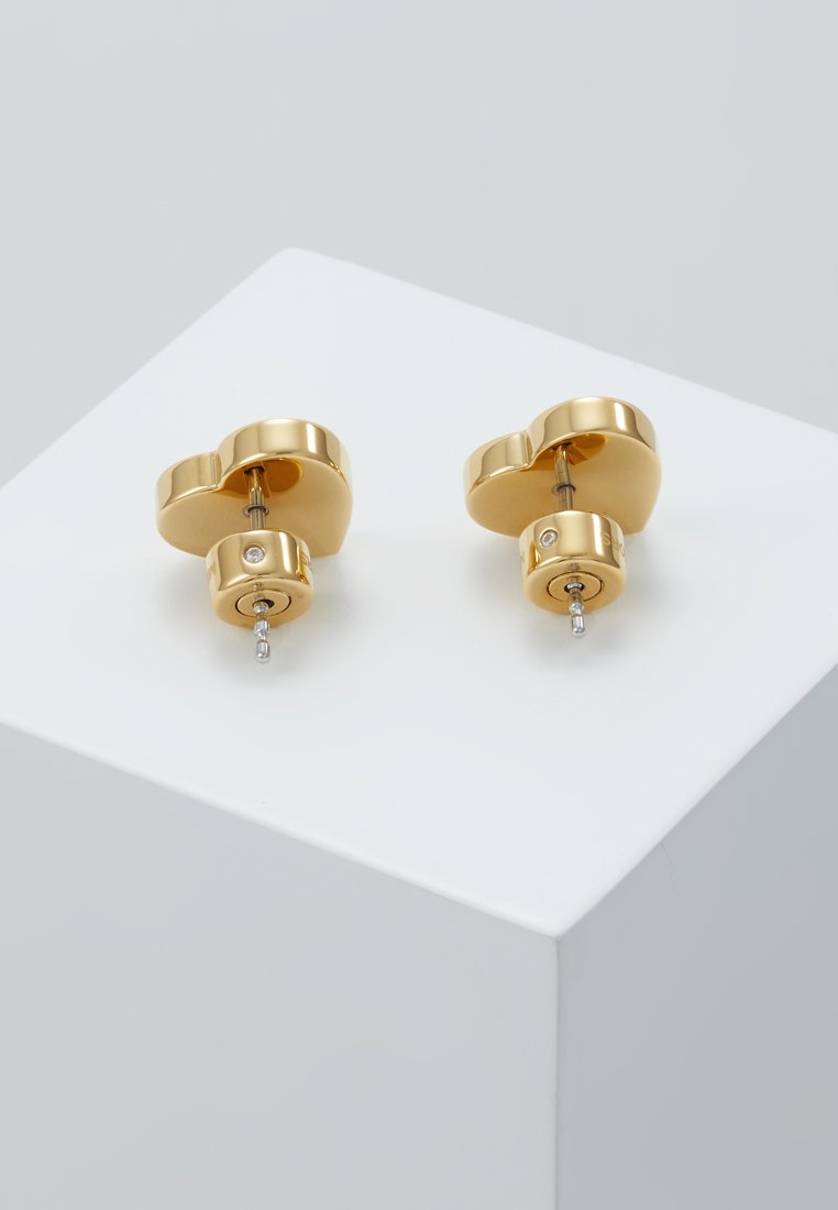 Orecchini a morsetto in metallo dorato con un design a vortice, decorati con un piccolo strass trasparente e dotati di una chiusura posteriore sicura.