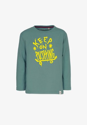 Pitkähihaiset, teal-väriset puuvillapaidat, joissa on suuri keltainen graafinen teksti "KEEP ON PUSHING" ja skateboard-suunnittelu alareunassa.