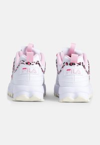 Baskets de sport blanches avec des accents roses, une tige texturée et un design de talon à motifs. Comprend des languettes de traction et une semelle épaisse.