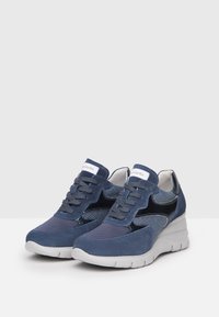 Zapatillas navy con una mezcla de materiales de ante y malla, con una suela acolchada, diseño de cordones y acentos en negro contrastantes.