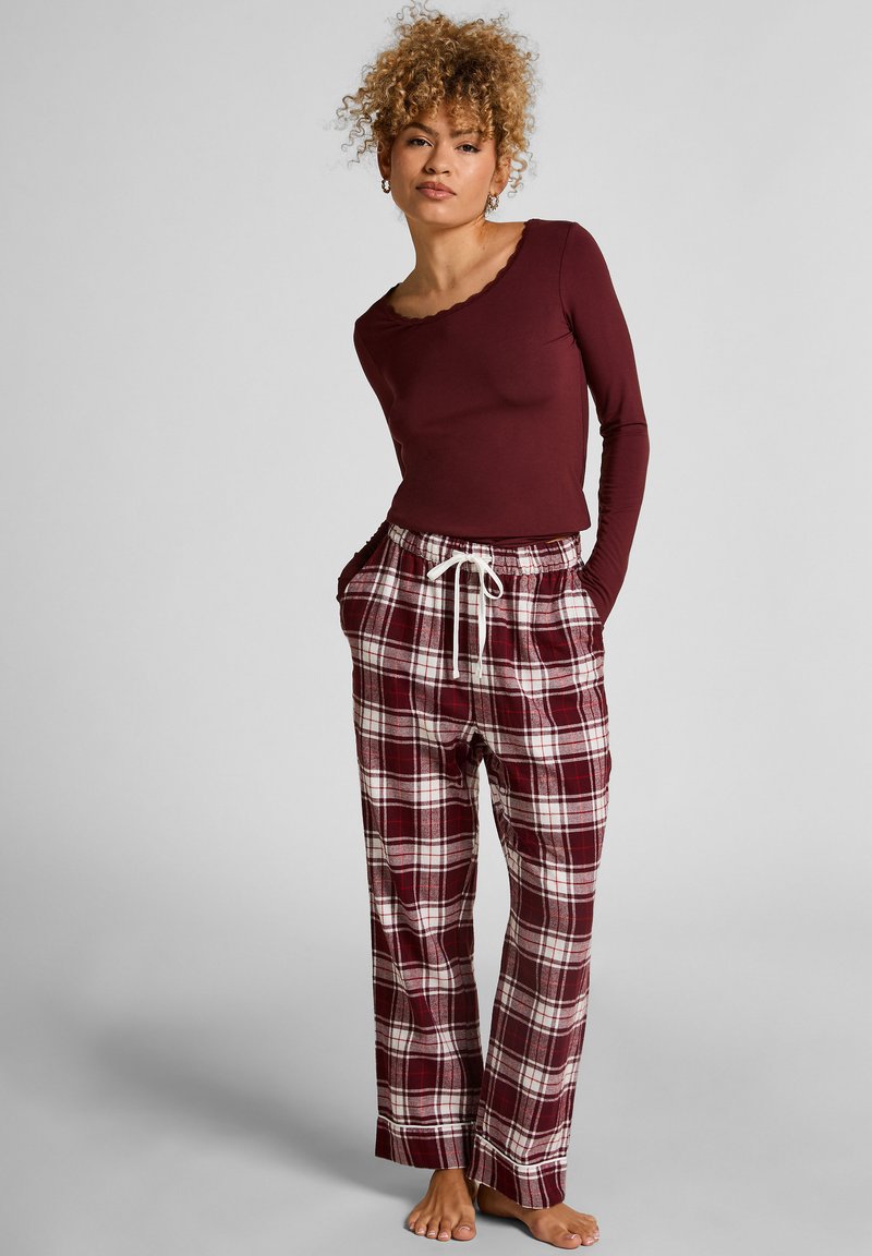 Bordeaux langemouwen top met een scalloped halslijn, gecombineerd met loose-fit geruite pyjamabroek in rood, wit en bordeaux, met een elastische tailleband.