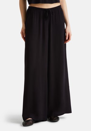 Black wide-leg pants made of lightweight fabric, featuring an elastic waistband with a drawstring detail and a textured surface.