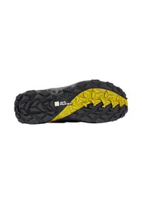 Schwarze und gelbe Gummisohle mit einem strukturierten Muster und tiefen Profilrillen für Traktion sowie einem auffälligen Logo der Marke.