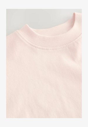 Vaaleanpunainen puuvillapaita, jossa on pyöristetty kaula-aukko ja sileä pinta, sekä huomaamaton ompelu yksityiskohta kauluksessa.