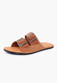 Sandale slide en cuir marron avec deux boucles en argent réglables et une semelle en caoutchouc noire, inclinée pour montrer les détails latéraux et supérieurs.