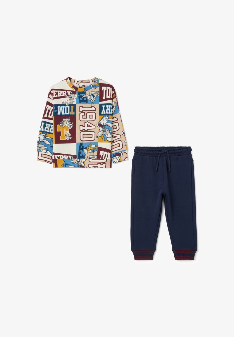 Geprinte longsleeve top in crème met veelkleurige grafische patronen, gecombineerd met marineblauwe joggingsbroek met een trekkoord in de taille.