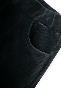 Crne korduroy hlače s rebrastom teksturom, s bočnom džepom i elastičnom pojasom za udobnost.
