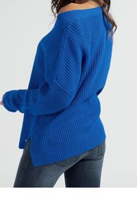 Übergroßer blauer Strickpullover mit geripptem Muster und weitem Ausschnitt. Mit langen Ärmeln und Seitenschlitzen für zusätzlichen Komfort.