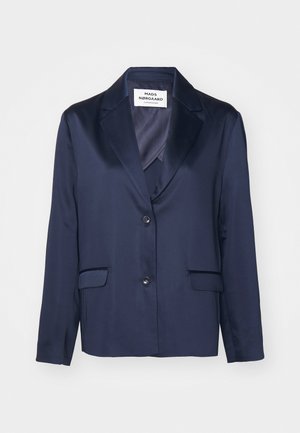 Laivastonsininen pikkutakki, joka on valmistettu sileästä kankaasta ja jossa on uusi lapel, yksinkertainen napitus ja kaksi etutaskua. Ominaisuudet yksinkertainen ja virtaviivainen muotoilu.