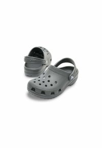 Grå Crocs-tofflor med perforerat mönster, baksnodd och kraftig sula. Tillverkade av lättviktigt material med en slät yta.
