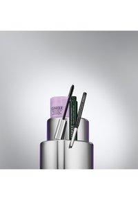 Clinique hudpleie- og sminkeprodukter inkluderer en lys lilla rensebalsam, svart mascara og eyeliner, anordnet på en sølvfarget, sirkelformet stativ.