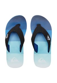 Blå gradient flip-flops med et tekstureret mønster. Sorte stofremme og et logo-patch på den ene side. Lys blå sål med en glat finish.