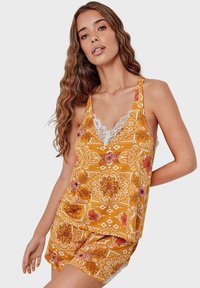 Yellow floral tank top with lace trim, featuring a V-neck design, intricate patterns, and a relaxed fit.