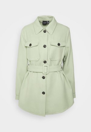 Lichtgroen lang mouw jasje met knopen, kraag, twee voorzakken met klep en bijpassende riem met rechthoekige gesp in de taille.