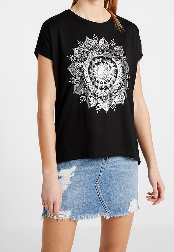 Svart bomulls-t-shirt med kort ärm, med en silver mandala design på framsidan; parat med en slitna denim minikjol.
