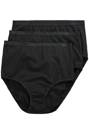 Femme souriante aux longs cheveux bruns posant avec la main sur la hanche, portant un soutien-gorge de sport noir et un sous-vêtement taille haute sur fond blanc.