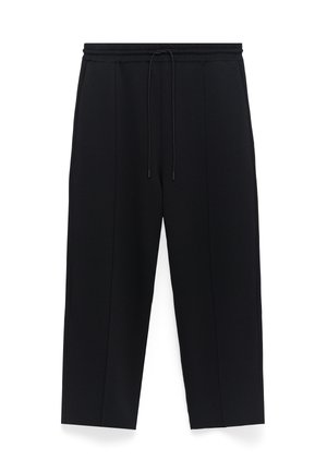 Zwarte broek met een relaxte pasvorm, voorzien van een elastische tailleband met trekkoord en zijnaad die langs de benen loopt. Glad stoftextuur.