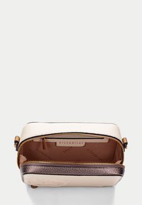 Sac synthétique texturé crème et bronze avec fermeture éclair. L'intérieur présente un imprimé logo et un compartiment spacieux. Accents bronze et matériel robuste.