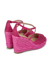 Sandalias de cuña rosa con una textura trenzada, adornadas con strass en las correas, y con una correa en el tobillo ajustable para un mejor ajuste.