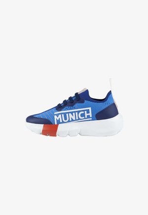 Zapatilla deportiva azul con parte superior de malla, branding blanco y un acento rojo en contraste en la suela. Cuenta con una media suela blanca acolchada y cordones negros.
