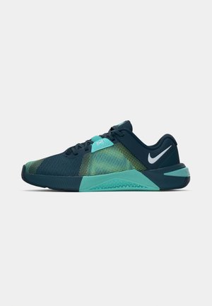 Navy and aqua athletic shoes with a textured mesh upper, featuring a green gradient pattern and a cushioned sole. Nike swoosh logo on heel.