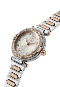 Hõbedane ja roosa kuldne metallkell tekstureeritud kreemja dials, Rooma numbrite, kristalli aktsentide ja läikiva lingiga rihmaga.