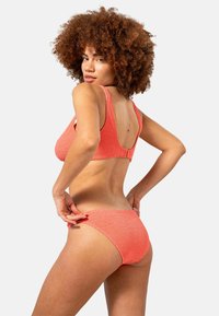 Korallfärgad bikini-set med strukturerad textur som har en bralette med djup rygg och tjocka remmar, samt matchande högmidjade shorts för en avslappnad passform.