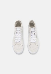 Witte canvas high-top sneakers met een geperforeerde neus, platte witte veters, versterkte oogjes en een grijs gestreept accent.