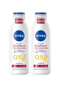 Zwei weiße Nivea Q10 Öl-Lotion-Flaschen mit blauen Kappen, gekennzeichnet für straffende, extra reichhaltige Winterpflege und trockene bis sehr trockene Haut.
