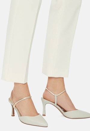 Décolleté slingback con punta affilata in pelle grigia chiara, con cinturino sottile metallizzato, tacco a stiletto e trama liscia opaca.