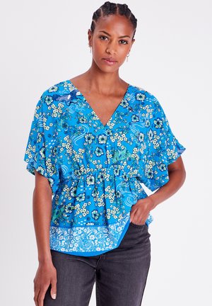 Blauwe bloemen peplum blouse met korte flutter mouwen, V-hals en een contrasterende geprinte zoom. Lichtgewicht stof met een zachte textuur.