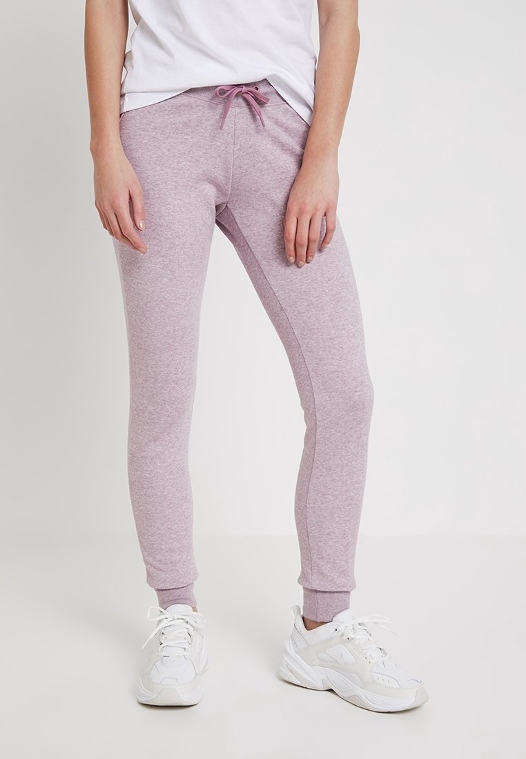 Lila joggers gjorda av mjukt tyg, med dragsko i midjan och smalnande mudd. Slät textur med sid sömmar för en strömlinjeformad look.