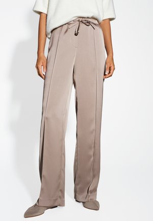Pantaloni beige a gamba larga con vita regolabile, realizzati in tessuto morbido e con cuciture frontali, caratterizzati da una texture liscia e fluida e da un design semplice.