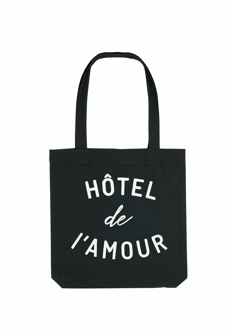 Sac en coton noir avec deux poignées solides. Présente un texte blanc indiquant "HÔTEL de l'amour" dans des tailles de police variées sur le devant.