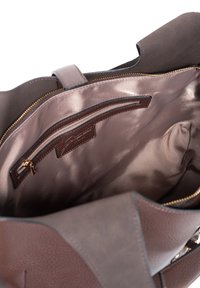 Brun lædertaske med en struktureret overflade, der har en glat, lys brun inderside og en lynlåslomme. Guldhardwaredetaljer er synlige.