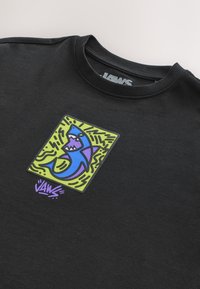 Black sweatshirt featuring a colorful shark graphic on a square background with wavy lines. "JAWS" logo is displayed in purple at the bottom.